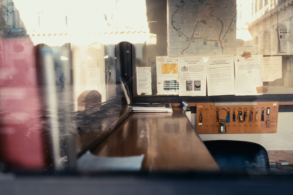Desk and key board behind a kiosk window with a city map, the street reflected in the glass