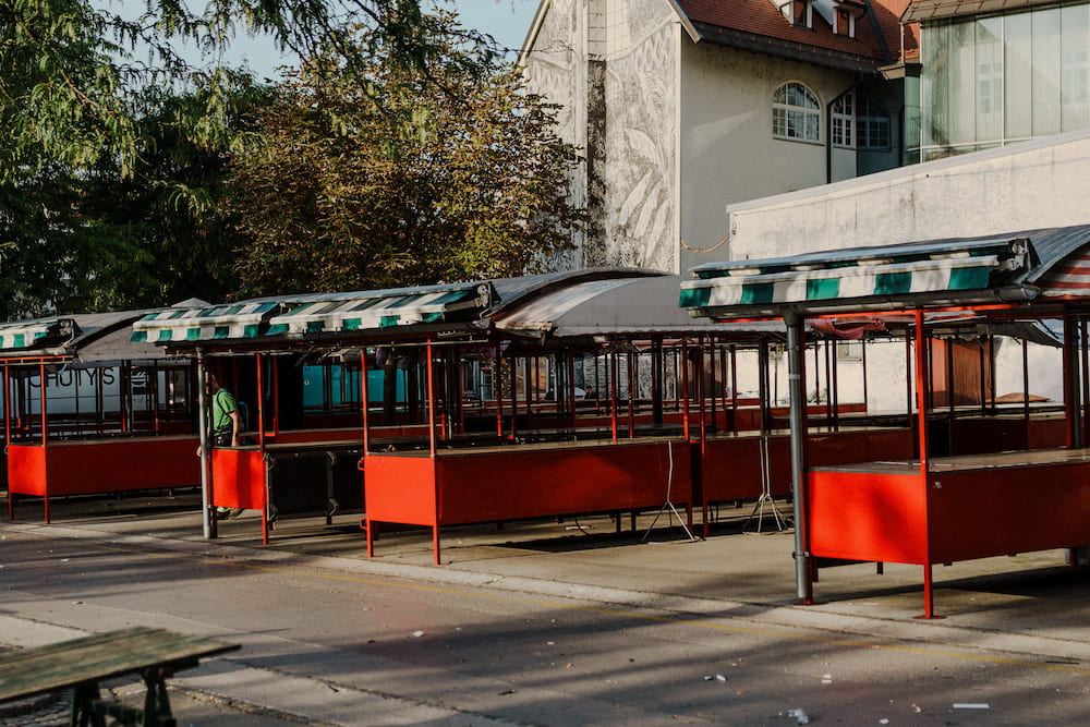 Red market stalls with striped awnings in warm evening light