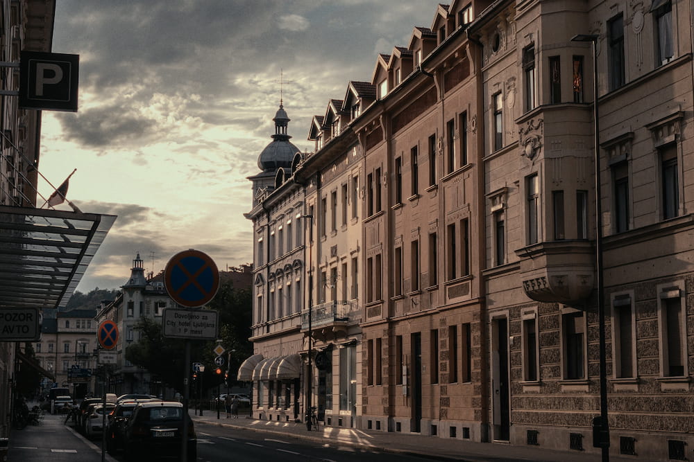 A street of old buildings in evening light, a parking sign on the left