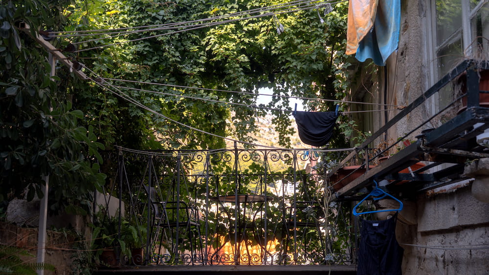 Vines and laundry over a small terrace.