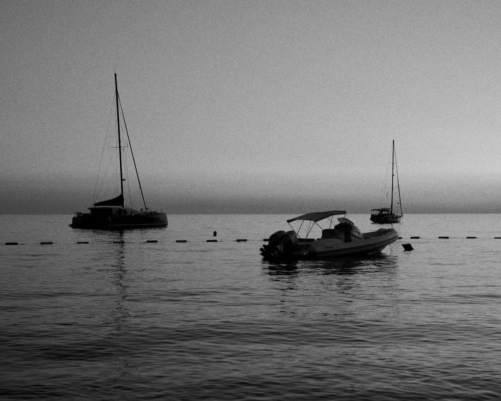 Black and white: a sailing boat and a motorboat at anchor