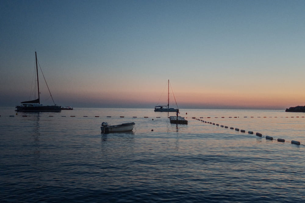 Sailing boats and a buoy line under an orange sky