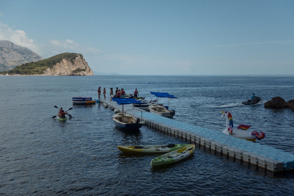 Kayaks and a floating pier off the beach, an island behind