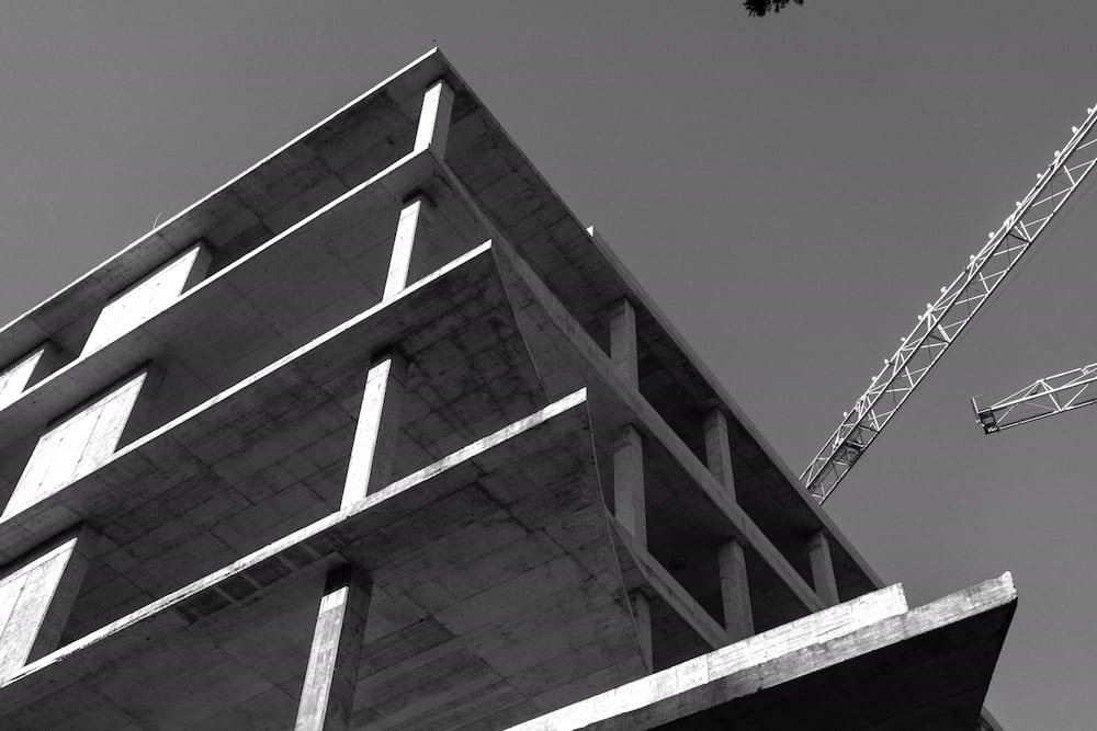 Black and white: concrete floor slabs and a crane against the sky