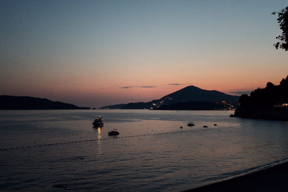 The bay after sunset, a small boat lit on the water