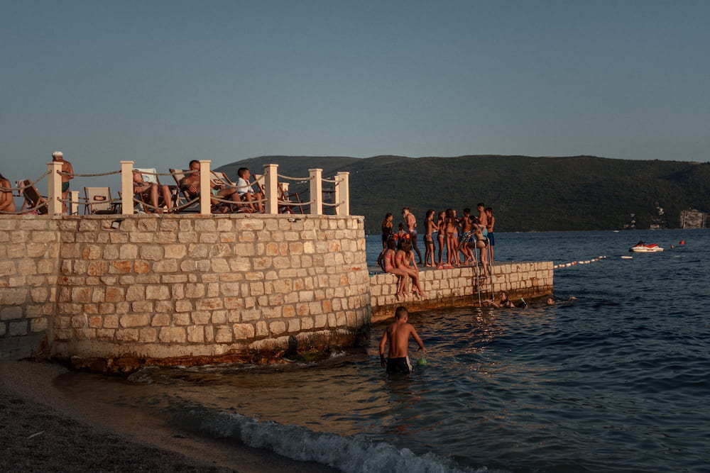 Swimmers by a stone wall with balustrades