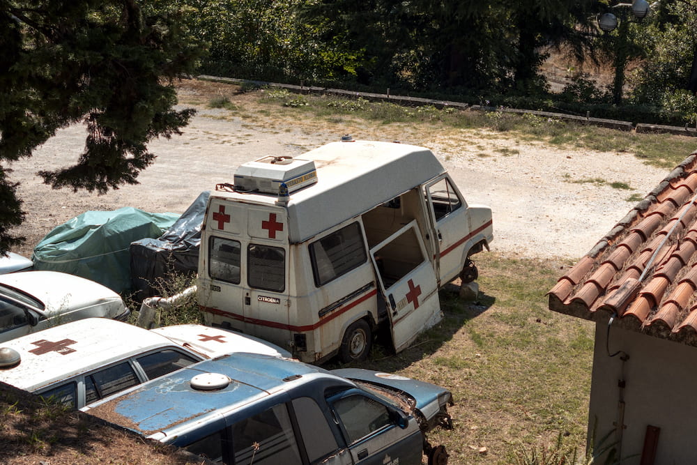Old ambulances parked under trees