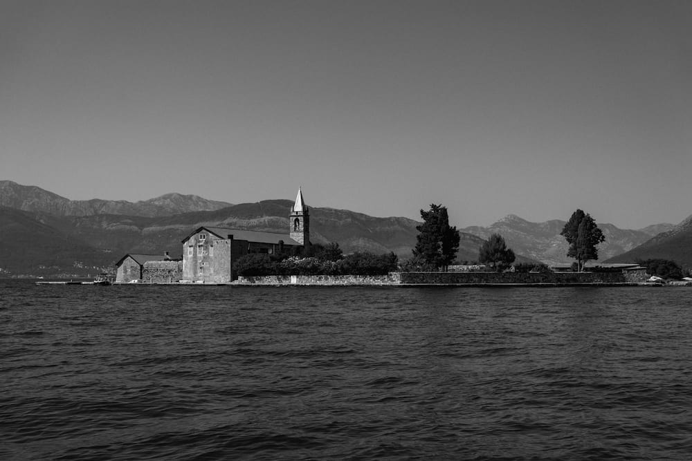 Black and white: a small island with a church and cypresses