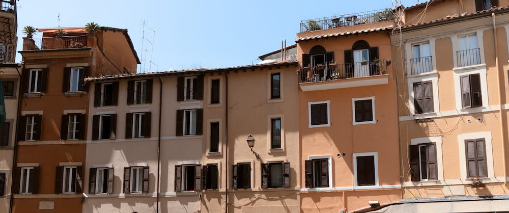 A row of ochre buildings against a blue sky, wide.
