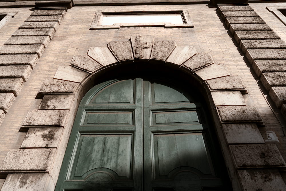 A large green door under a stone arch.