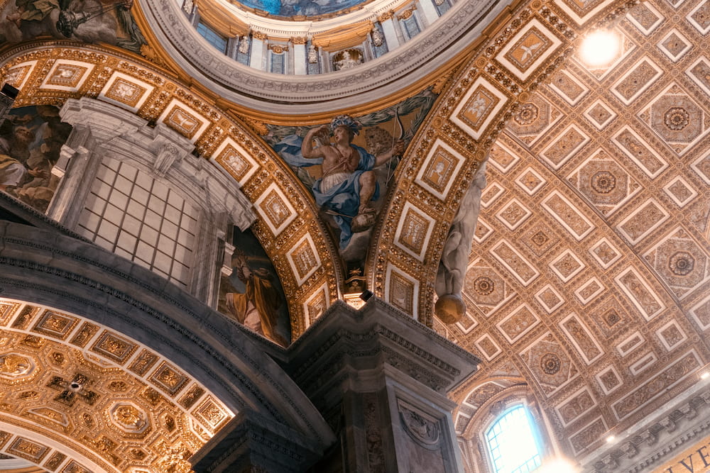 Gilded coffered arches and a dome, from below.